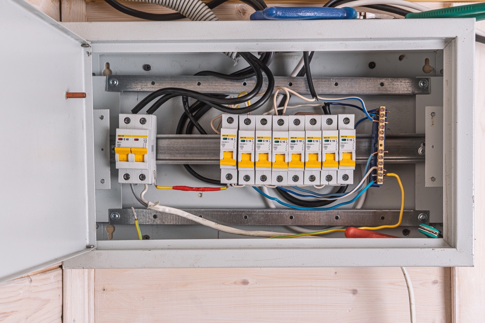 Open electrical panel with neatly arranged circuit breakers and colorful wires highlights organized wiring and safety in home power distribution.